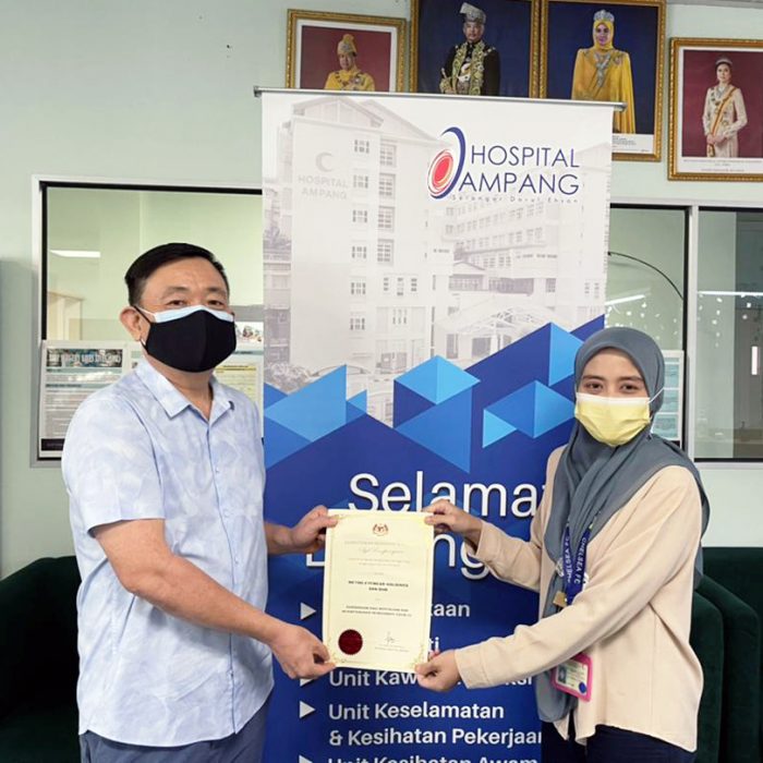 A picture featuring Dato' Henry Ng (left) and the vice-president of Hospital Ampang (right) holding the certificate of appreciation.
